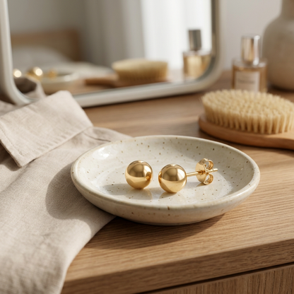 Gold-tone ball stud earrings styled on a morning vanity